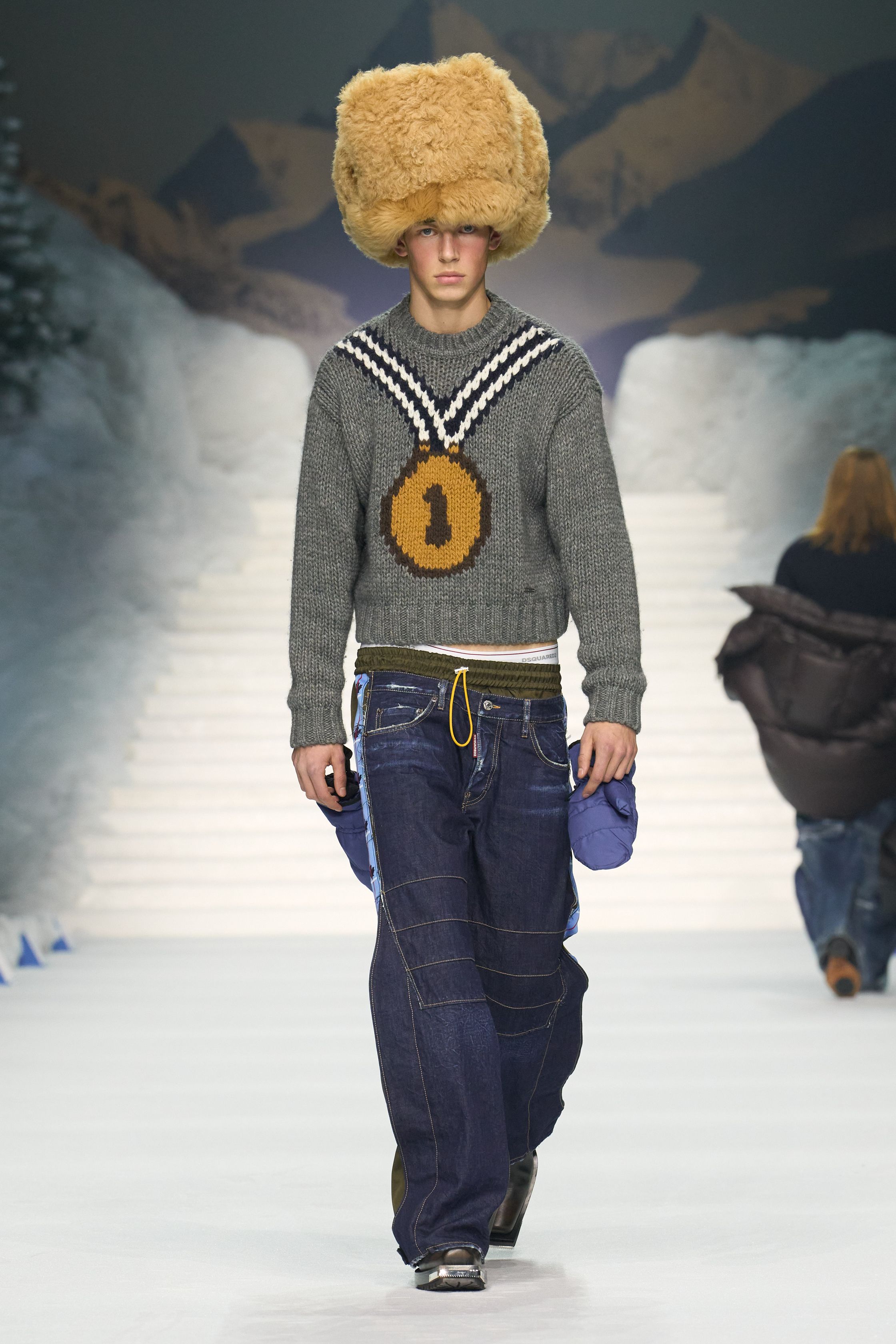 Dsquared2 2026秋冬以夸张的滑雪场景为背景，将加拿大户外精神、Y2K 性感与舞台化时装推至极致。羽绒、毛皮、紧身牛仔与夸张比例不断叠加，身体成为视觉焦点，性感、力量与炫耀被无限放大。这不是现实主义的衣橱，而是一场关于冒险、欲望与表演的时尚狂欢，张扬而直接，忠于品牌一贯的高能量叙事-顽石频道趋势研究